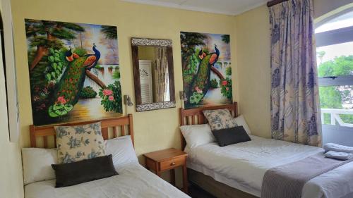 a small room with two beds and a mirror at Caribbean Estates Montego bay 30 in Port Edward