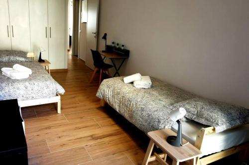 Cette chambre comprend deux lits et un bureau. dans l'établissement Santa Severina, Trilocale comodo e pratico centro città, à Menton