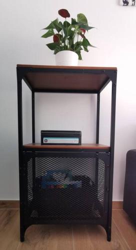 une étagère noire avec une plante en pot au-dessus de celle-ci dans l'établissement Santa Severina, Trilocale comodo e pratico centro città, à Menton