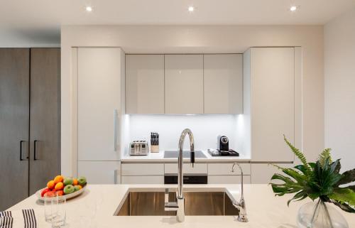 a kitchen with white cabinets and a sink at Goldwynn Resort & Residences in Nassau