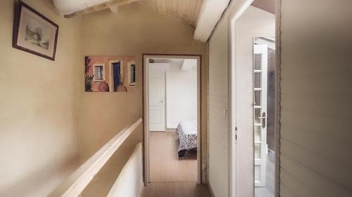 een hal met een spiegel en een bed in een kamer bij ZENSAN Meublé Maison de Village Le Boulou 66160 in Le Boulou