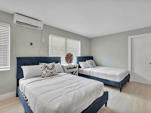 a bedroom with two beds and a bed and a window at The Shell on Walnut Studio Hollywood Beach Free Parking in Dania Beach