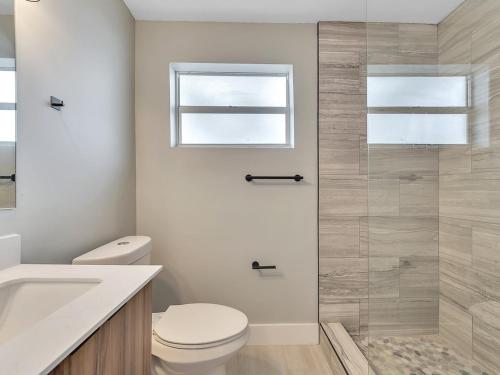 a bathroom with a toilet and a glass shower at The Shell on Walnut Studio with Bath Hollywood Beach Free Parking in Dania Beach