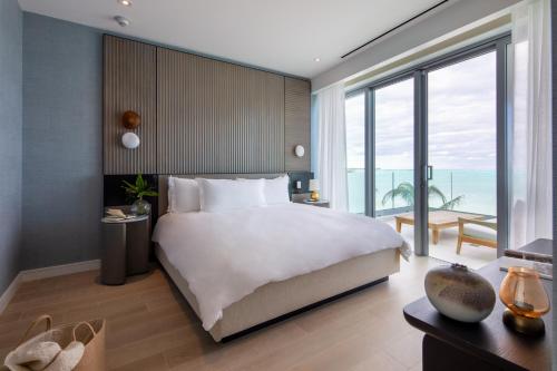 a bedroom with a large bed and a large window at Goldwynn Resort & Residences in Nassau