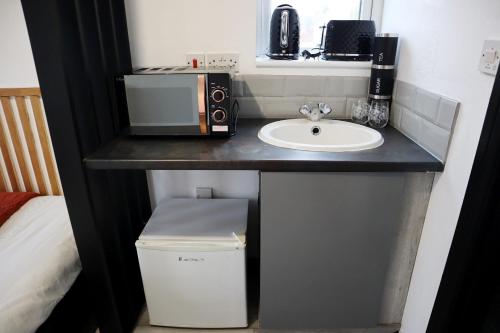 a bathroom counter with a sink and a microwave at 259A Queen Ediths Way in Cherry Hinton