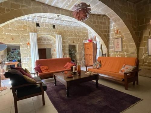a living room with two couches and a table at Dar Dragun: luxury 3BR bright spacious house & pool in San Lawrenz