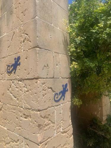 a wall with blue graffiti on the side of it at Dar Dragun: luxury 3BR bright spacious house & pool in San Lawrenz