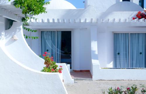 a white house with flowers on the stairs at Al Jazira Beach & Spa- All Inclusive - Families and Couples Only in Houmt Souk