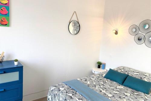 une chambre avec un lit et une horloge au mur dans l'établissement Le Colvert-Charmant appart proche centre et gare, au Havre