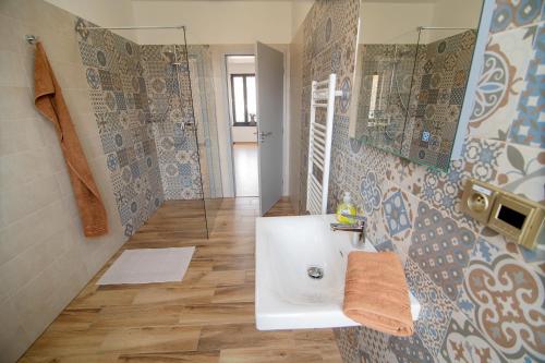 a bathroom with a sink and a glass shower at Penzion U Vinaře in Mikulov