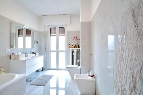 a white bathroom with two sinks and a toilet at Lux 180sqm flat - entire last floor in Milan