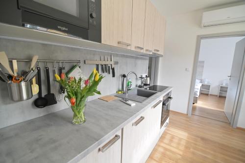 a kitchen with a sink and a vase of flowers at Penzion U Vinaře in Mikulov