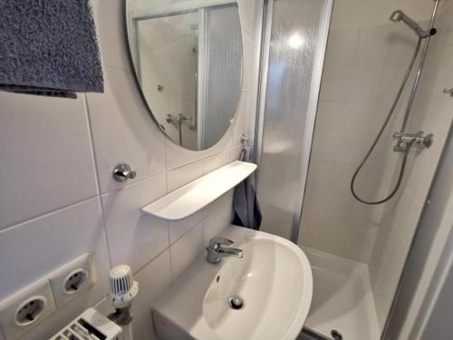 La petite salle de bains est pourvue d'un lavabo et d'un miroir. dans l'établissement Strandlicht, à Horumersiel