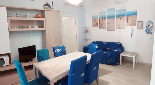 uma sala de estar com cadeiras azuis e uma mesa em I Velieri em Cesenatico