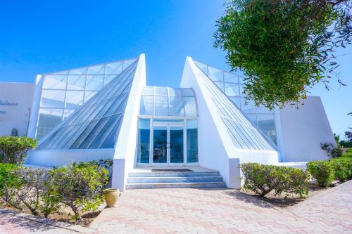 Un grand bâtiment blanc avec des escaliers se trouve juste devant. dans l'établissement Al Jazira Beach & Spa- All Inclusive - Families and Couples Only, à Houmt Souk