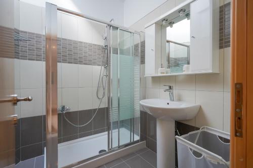 a bathroom with a glass shower and a sink at Kyriakos Apartment in Mastichari