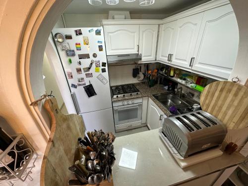 an overhead view of a kitchen with a white refrigerator at FLAT Surrounded by Nature WIFI & Pool & beach Nearby in Son Parc