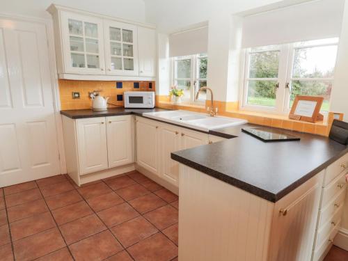 a kitchen with white cabinets and a black counter top at The Steadings in Morpeth