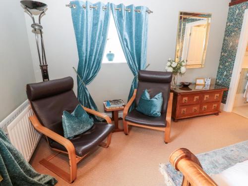 a living room with two chairs and a mirror at The Steadings in Morpeth