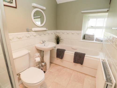 a bathroom with a sink and a toilet and a bath tub at The Steadings in Morpeth