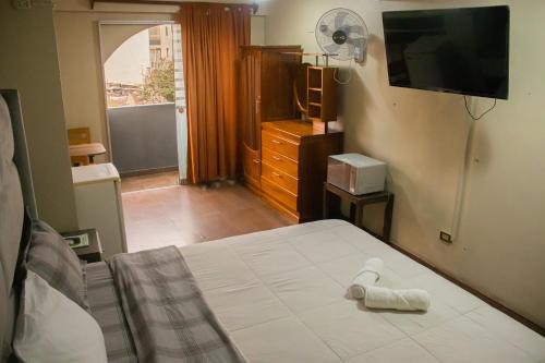 a bedroom with a bed with a towel on it at Hostel THAY83 Miraflores Lima in Lima