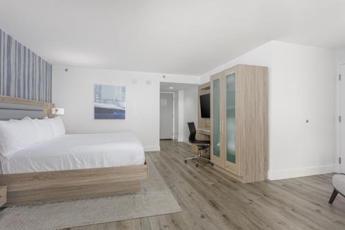 a bedroom with a bed and a desk and a television at Perdido Beach Resort in Orange Beach