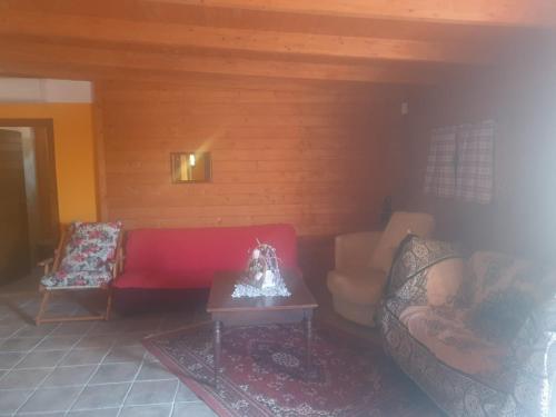 - un salon avec un canapé rouge et une table dans l'établissement La casetta del bosco, à Marta