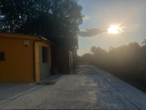 Une rue vide où le soleil se lève derrière un bâtiment dans l'établissement La casetta del bosco, à Marta