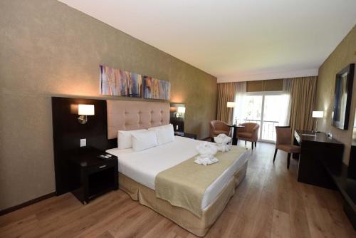 um quarto de hotel com uma cama grande e uma secretária em Howard Johnson Resort & Convention Center Ezeiza em Ezeiza