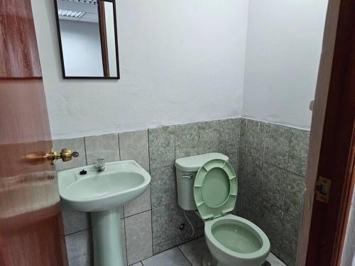 a bathroom with a sink and a toilet and a mirror at Cozzy apartment en pleno Centro! in Ayacucho
