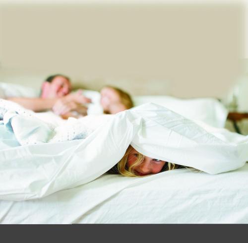 a group of people laying in bed under a blanket at Country Inn & Suites by Radisson, Katy Houston West , TX in Katy