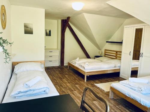 a attic room with two beds and a table at Chalupa Bořanovice in Vimperk