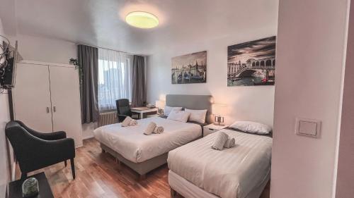Cette chambre comprend deux lits et un bureau. dans l'établissement Apartments am Rheingarten, à Cologne