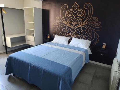 a bedroom with a blue bed with a gold design on the wall at 787 Suites in La Cieneguita