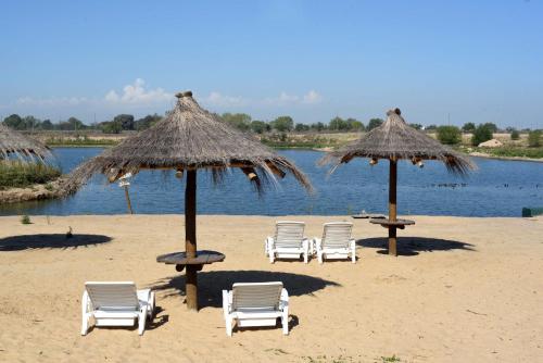 a group of chairs and umbrellas on a beach at Howard Johnson Resort & Convention Center Ezeiza in Ezeiza