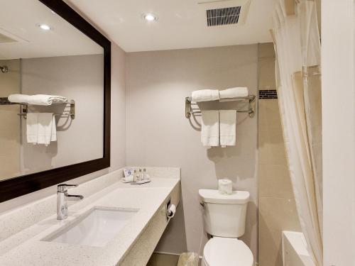 a bathroom with a sink and a toilet and a mirror at Travelodge by Wyndham Cambridge - Waterloo in Cambridge