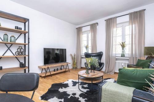 Center Dream Apartment - Netflix في كريفيلد: غرفة معيشة مع أريكة وتلفزيون
