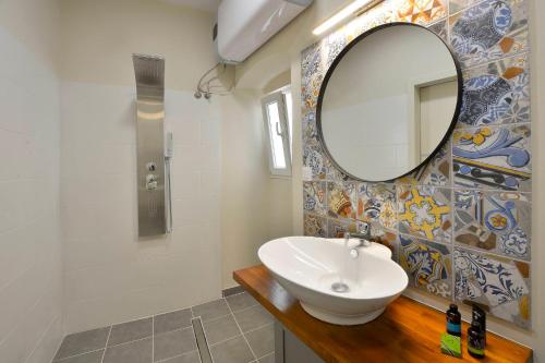 uma casa de banho com um lavatório e um espelho em Beau Maison em Corfu Town