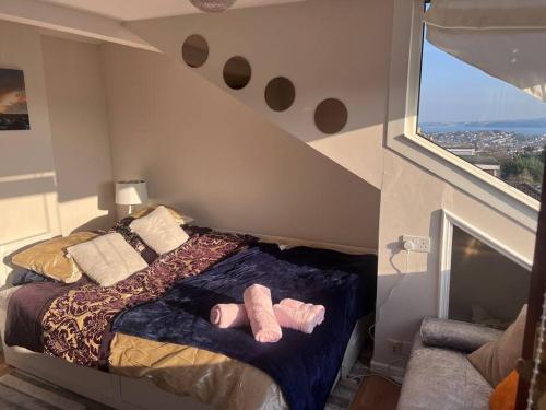 una camera da letto con un letto con due calzini rosa sopra di Bay View Retreat a Paignton