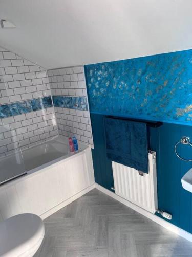 a bathroom with a tub and a toilet and a sink at Bay View Retreat in Paignton