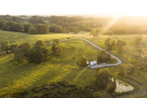 an aerial view of a road in a field with a house at freed.Omspace in Broken Head