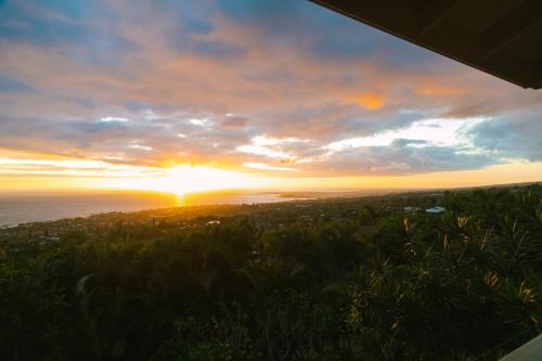 a sunset over the ocean with the sun in the sky at Kailua-Kona Exceptional Oceanview Home - Heated Oasis Pool & Stunning Ocean View in Kailua-Kona