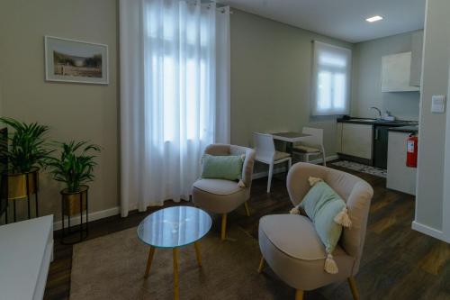 a living room with chairs and a table and a kitchen at Blue House in Ponta do Sol