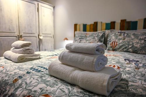 una pila de toallas sentadas encima de una cama en Profumo di Bosco en Spoleto