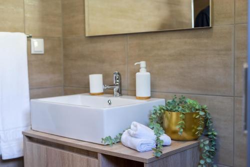 La salle de bains est pourvue d'un lavabo et de serviettes sur une table en bois. dans l'établissement Blue House, à Ponta do Sol
