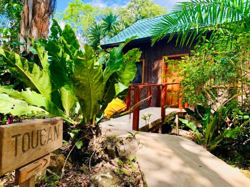 a resort with a sign in front of a house at Mariposa Jungle Lodge in San Ignacio