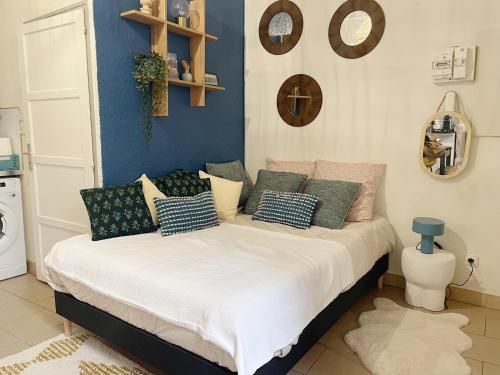 een slaapkamer met een bed met kussens erop bij Charme & calme à 200m du Château in Blois