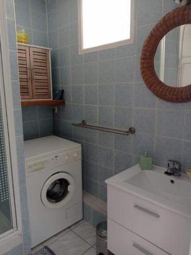 une salle de bain avec une machine à laver et un lavabo dans l'établissement Charmant studio fonctionnel avenue des alliés, à Cavalaire-sur-Mer