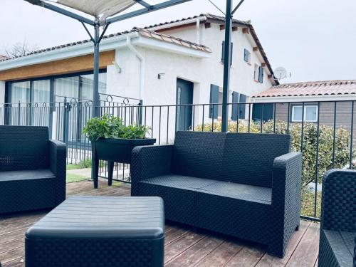 a patio with two chairs and a table on a deck at Maison Spacieuse au Calme Piscine Privée in Boudy