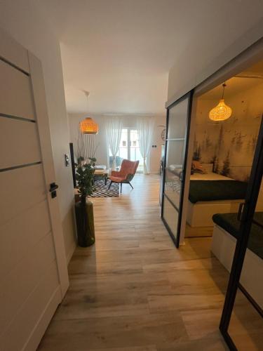 a hallway with a room with a bed and a table at Przytulny apartament nad morzem - RUSINOWO in Rusinowo
